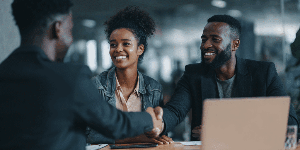 couple se faisant conseiller par un financier et serrant la main entre les deux hommes