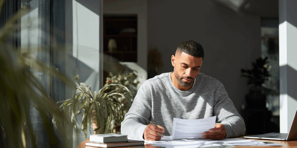 Un homme en train de regarder des papiers chez lui