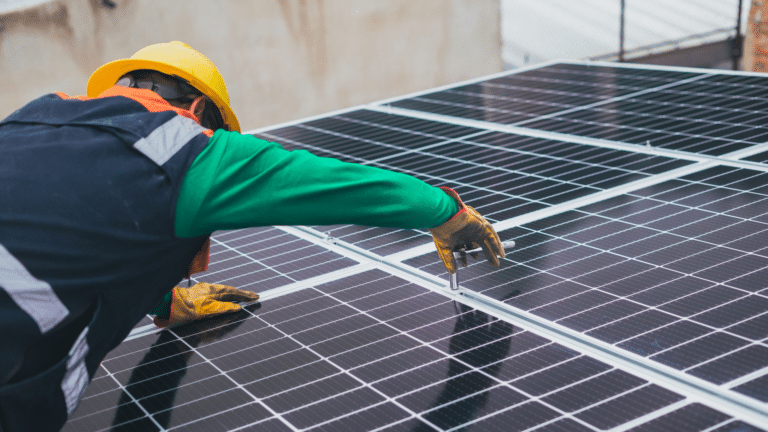 Un installateur qui règle des panneaux solaires | Financer un projet solaire sans mobiliser sa trésorerie